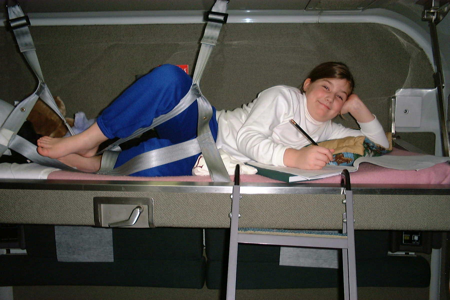 Danielle writing in her journal in the top bunk of the auto train