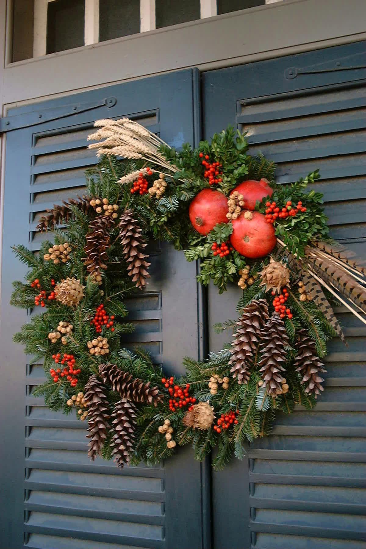 Colonial Williamsburg Christmas wreath with pinecones and pomegranates on blue shutters